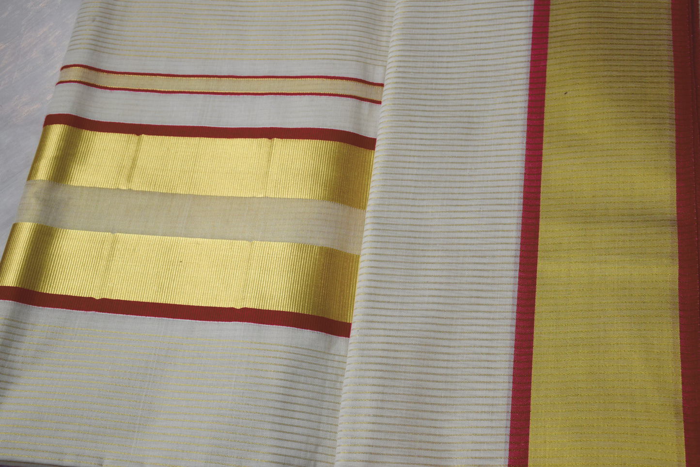 This Kerala Onam saree showcases traditional kasavu craftsmanship with striking red accents, reflecting the cultural essence of Kerala’s Onam festival. 