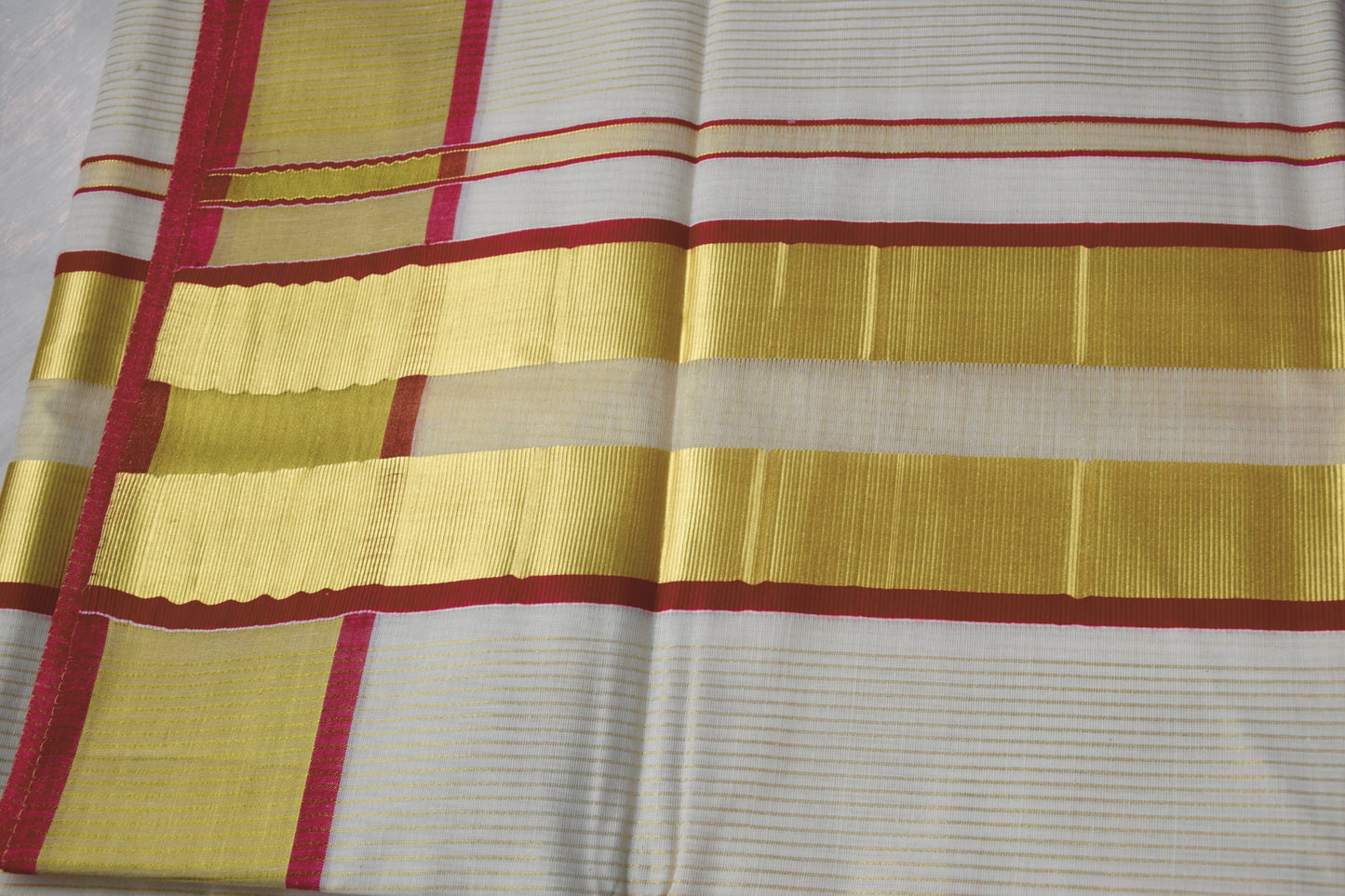 This Kerala Onam saree showcases traditional kasavu craftsmanship with striking red accents, reflecting the cultural essence of Kerala’s Onam festival. 