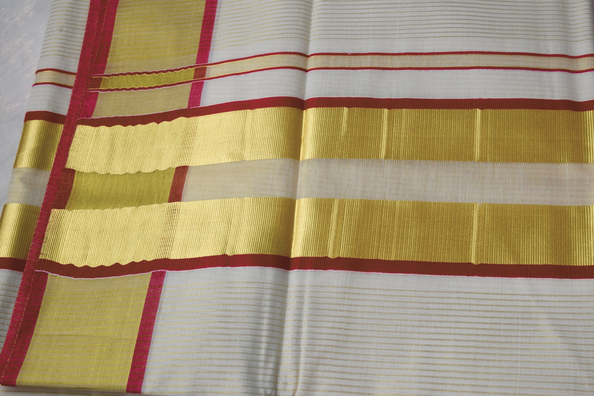 This Kerala Onam saree showcases traditional kasavu craftsmanship with striking red accents, reflecting the cultural essence of Kerala’s Onam festival. 