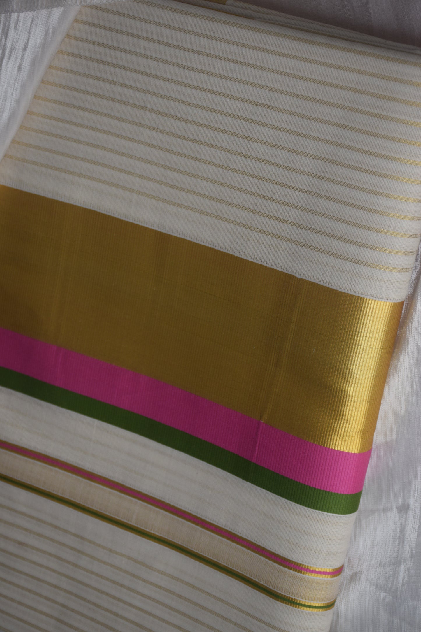 This traditional Kerala saree features a vibrant combination of pink and green hues, expertly woven in breathable cotton fabric. The intricate gold zari work adds a touch of opulence, reflecting the rich cultural craftsmanship of Kerala. Ideal for those who appreciate authentic heritage textiles with a sophisticated finish. Pink kerala saree in cotton

