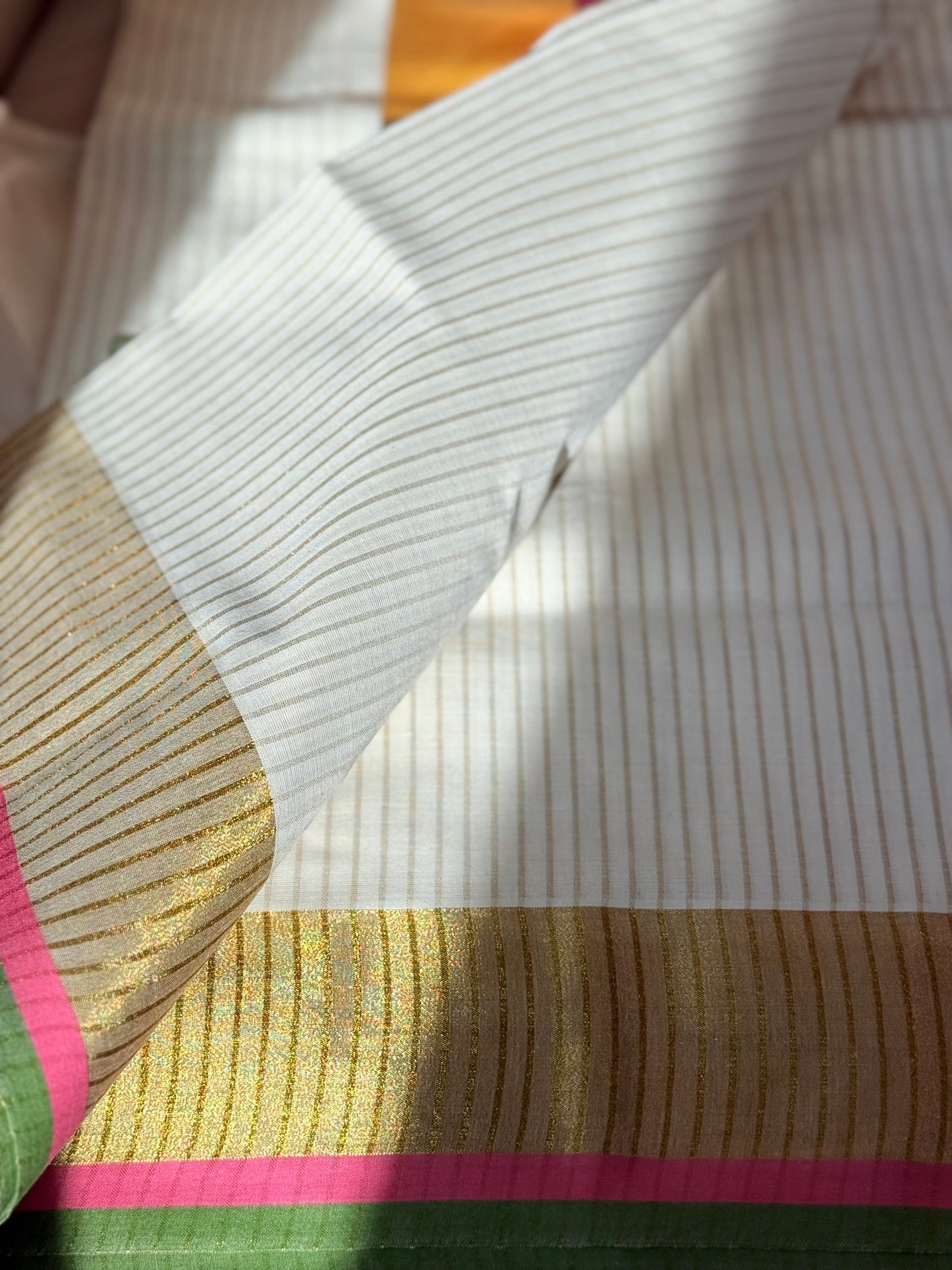 This traditional Kerala saree features a vibrant combination of pink and green hues, expertly woven in breathable cotton fabric. The intricate gold zari work adds a touch of opulence, reflecting the rich cultural craftsmanship of Kerala. Ideal for those who appreciate authentic heritage textiles with a sophisticated finish. Pink kerala saree in cotton

