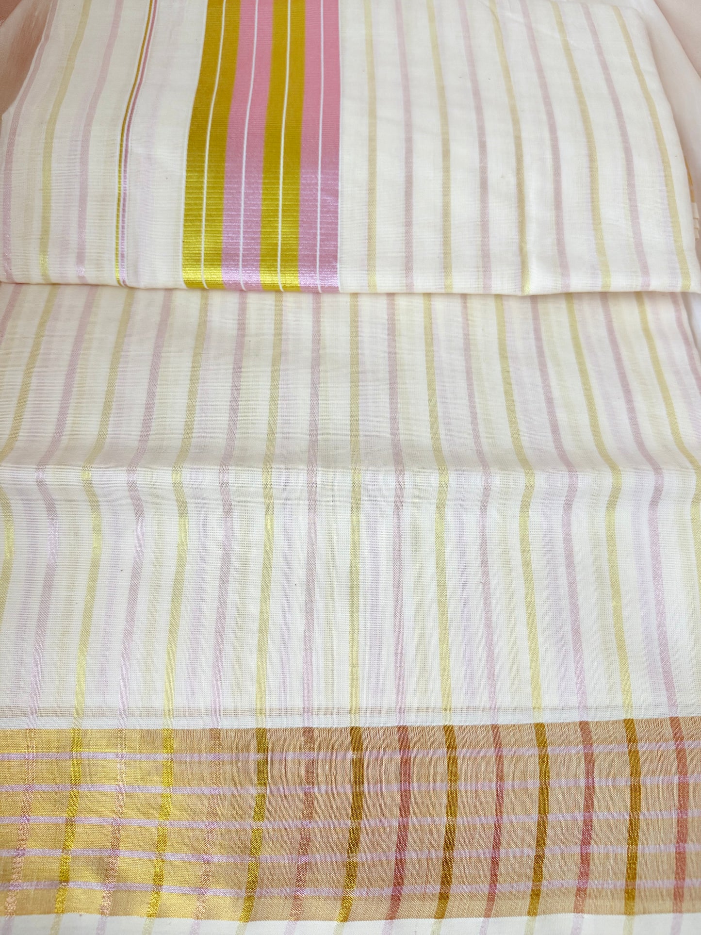 This Kerala saree features elegant pink and green stripes, blending traditional craftsmanship with vibrant colors. 