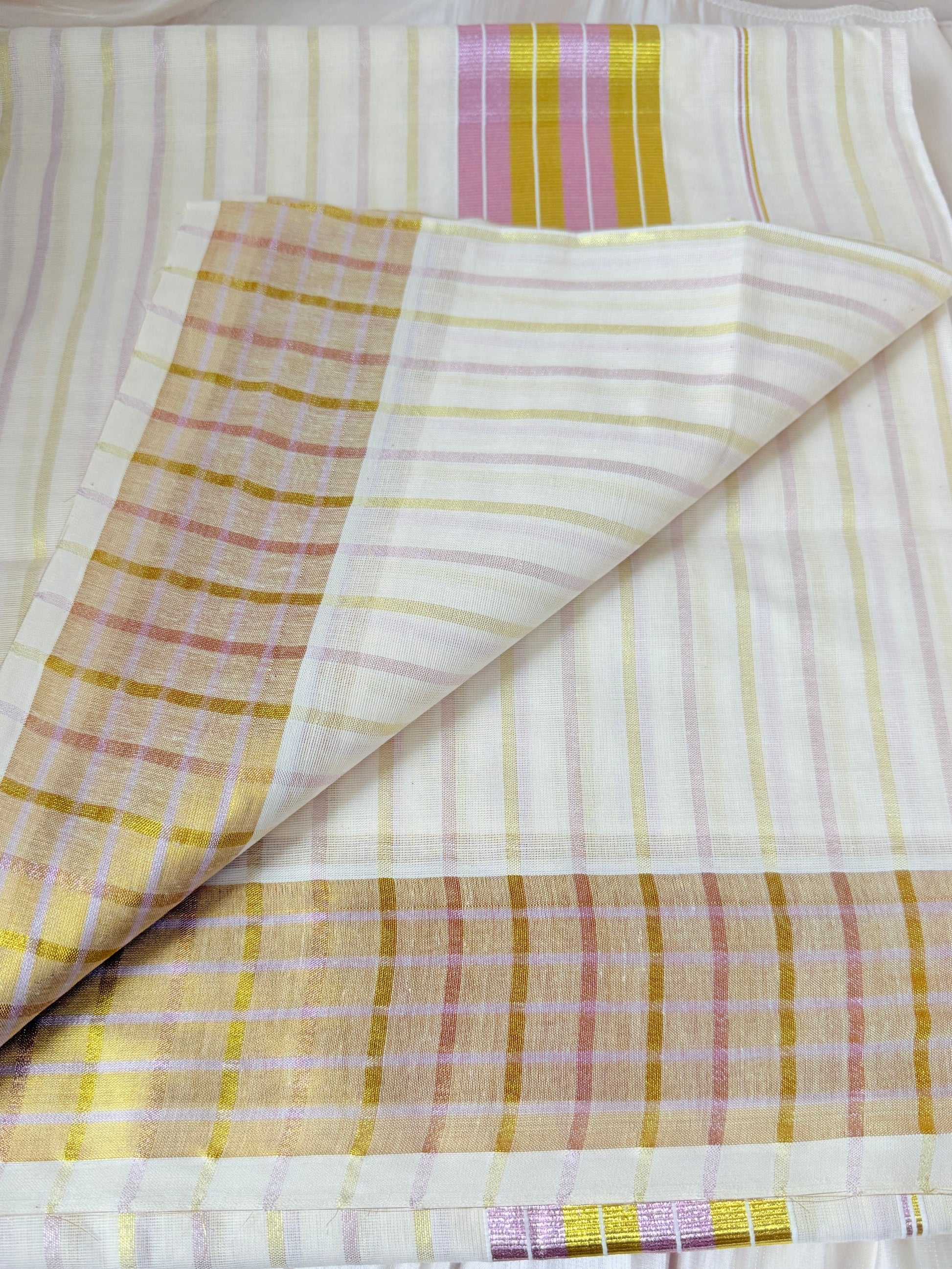 This Kerala saree features elegant pink and green stripes, blending traditional craftsmanship with vibrant colors. 