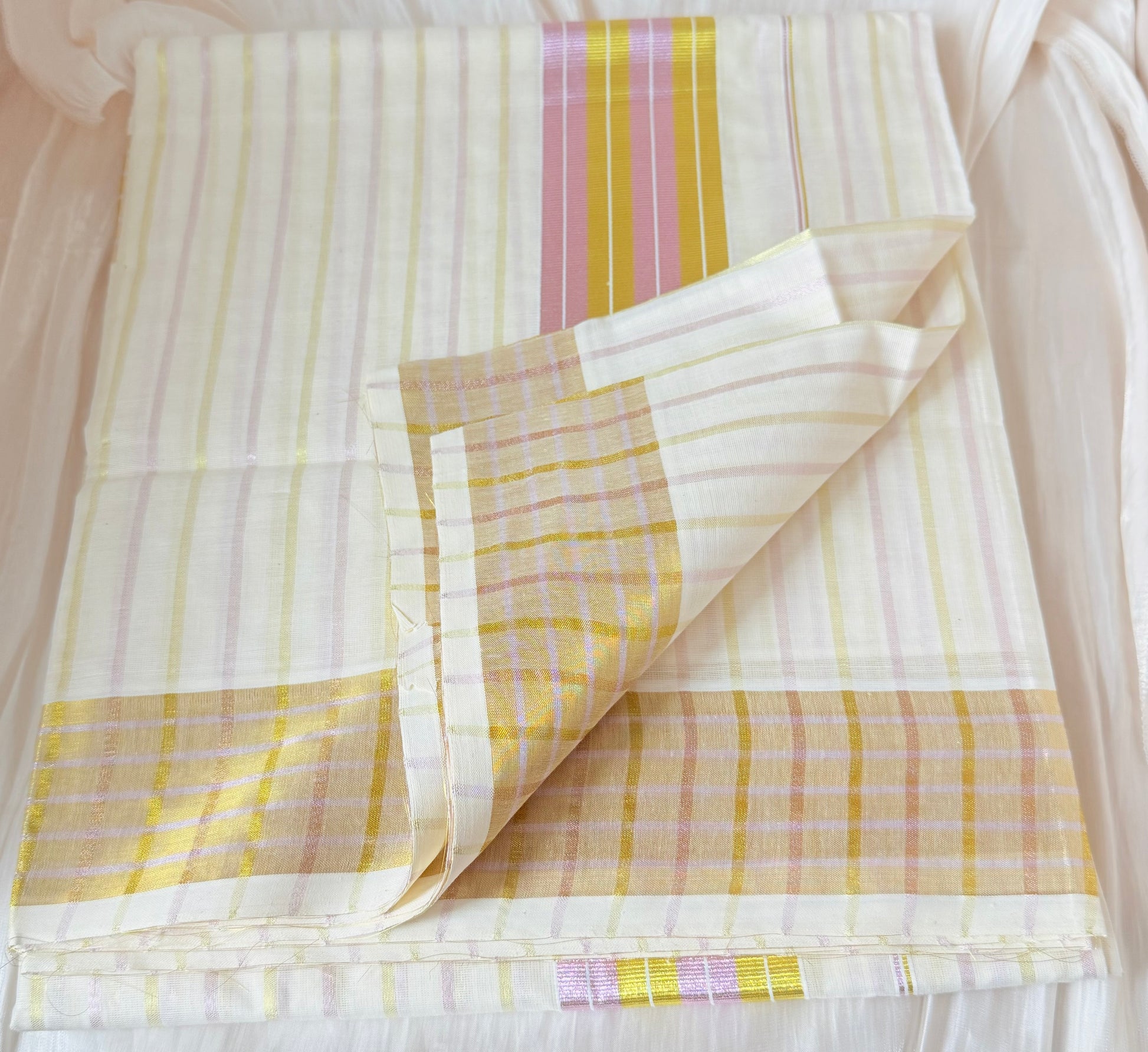 This Kerala saree features elegant pink and green stripes, blending traditional craftsmanship with vibrant colors. 