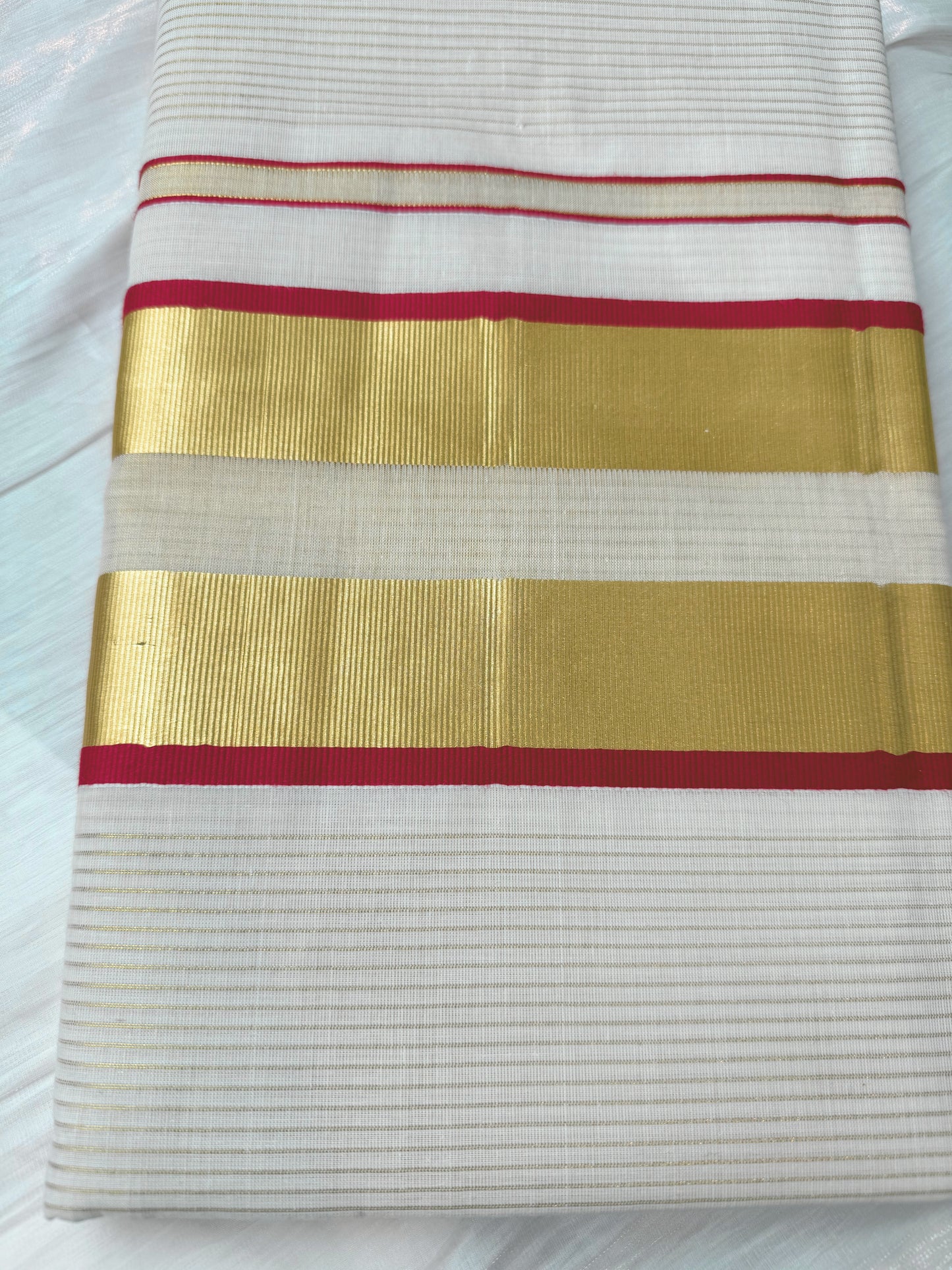 This Kerala Onam saree showcases traditional kasavu craftsmanship with striking red accents, reflecting the cultural essence of Kerala’s Onam festival. 