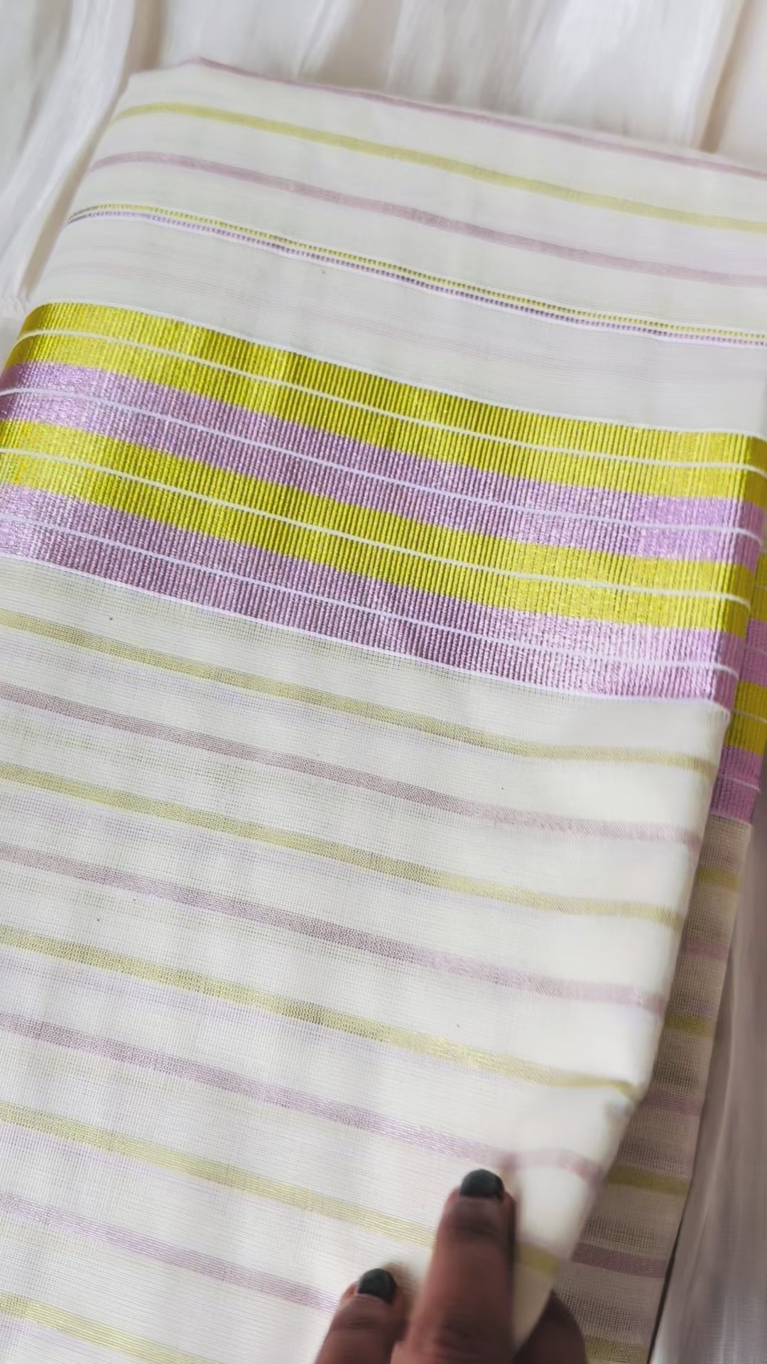 This Kerala saree features elegant pink and green stripes, blending traditional craftsmanship with vibrant colors. 